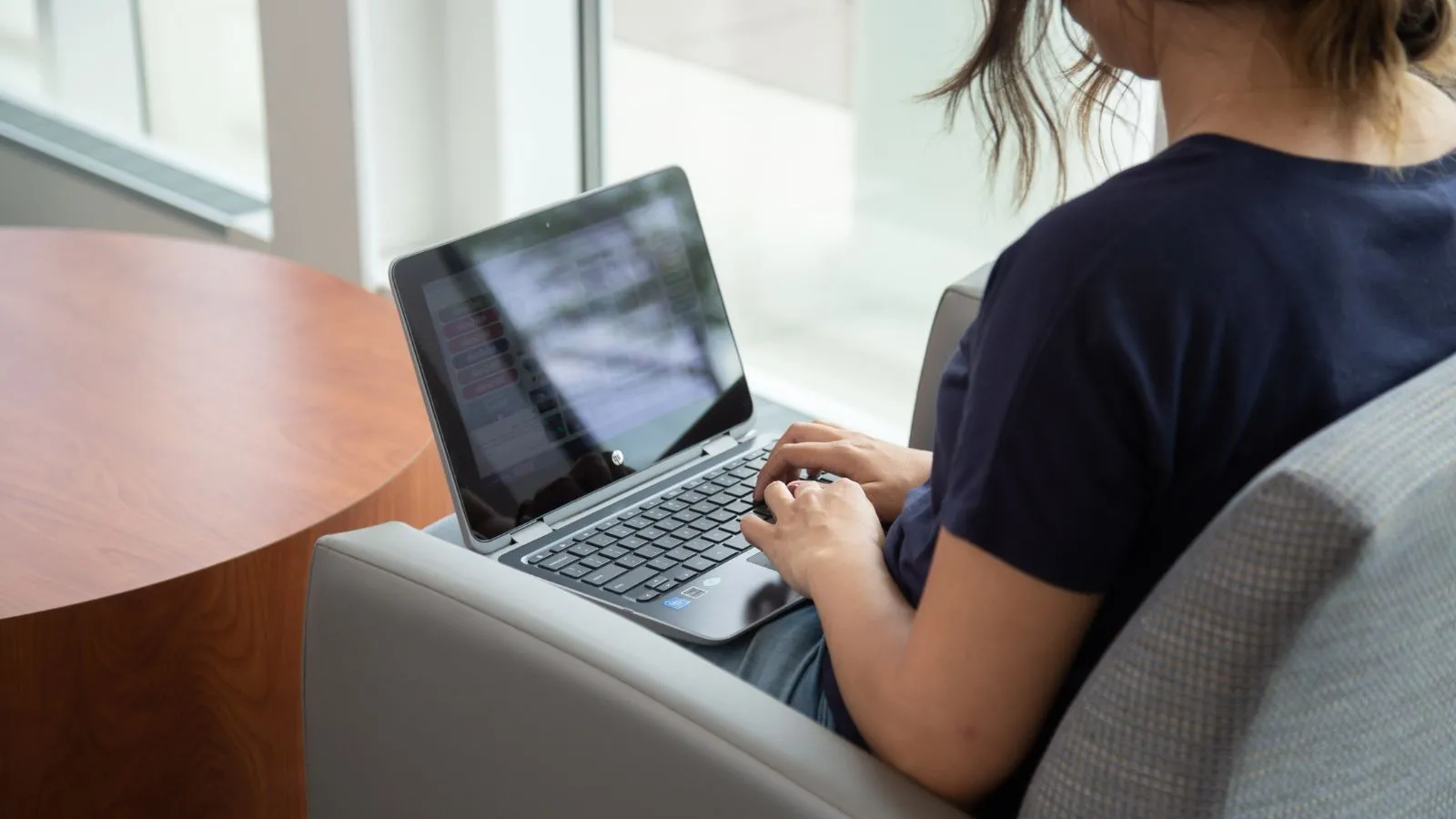 Student sitting down typing on a laptop 