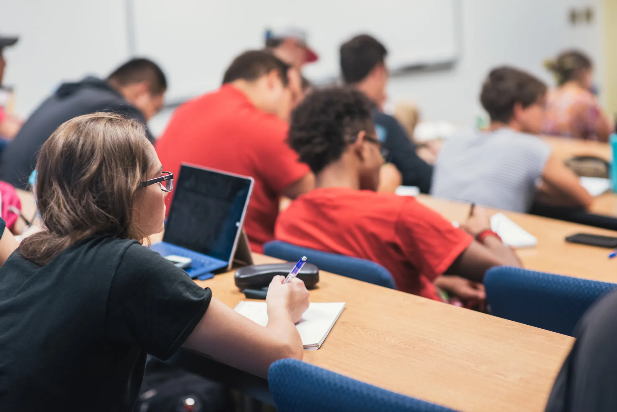 Students listening to a lecture and writing notes