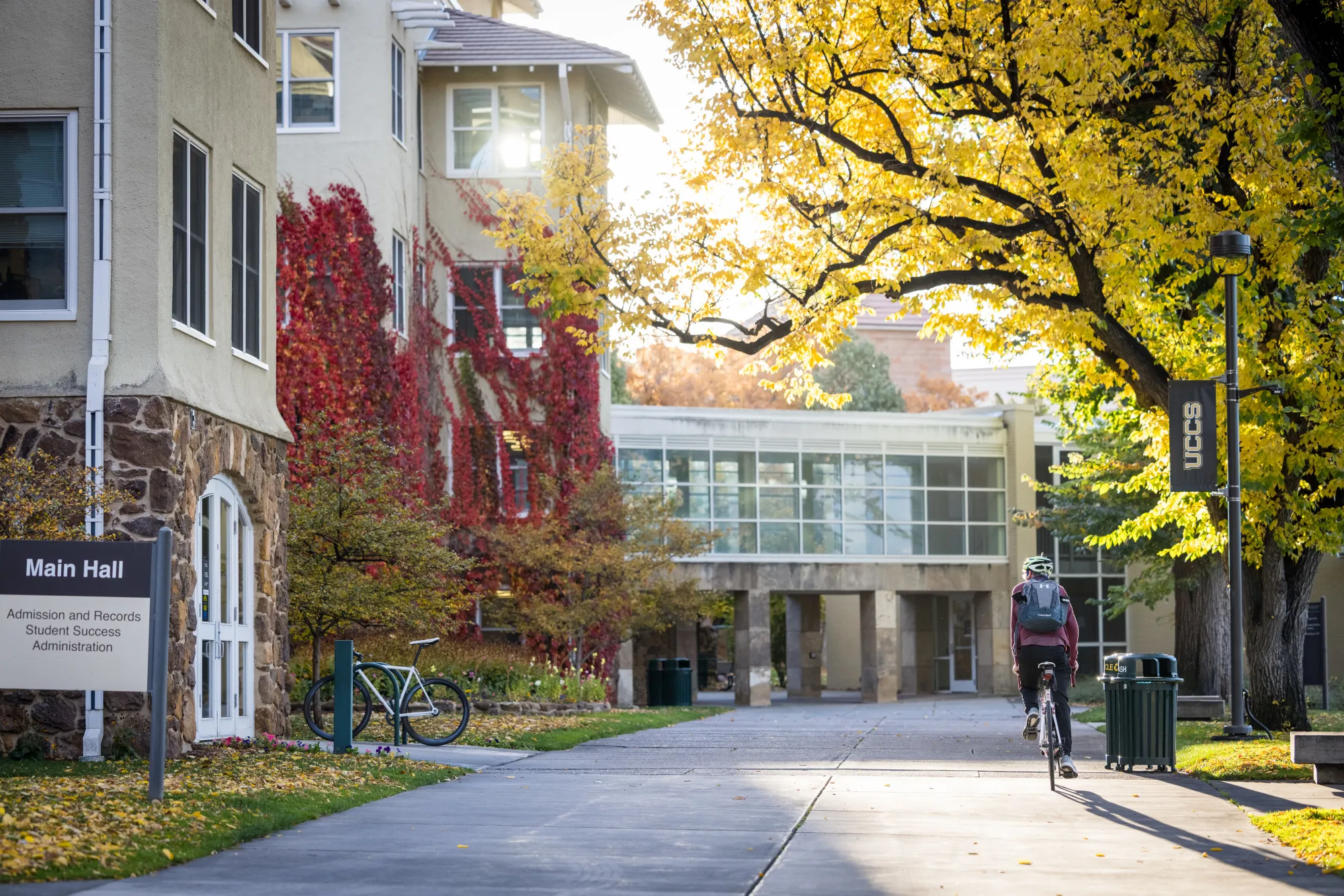 Picture of main hall with a student biking by it 